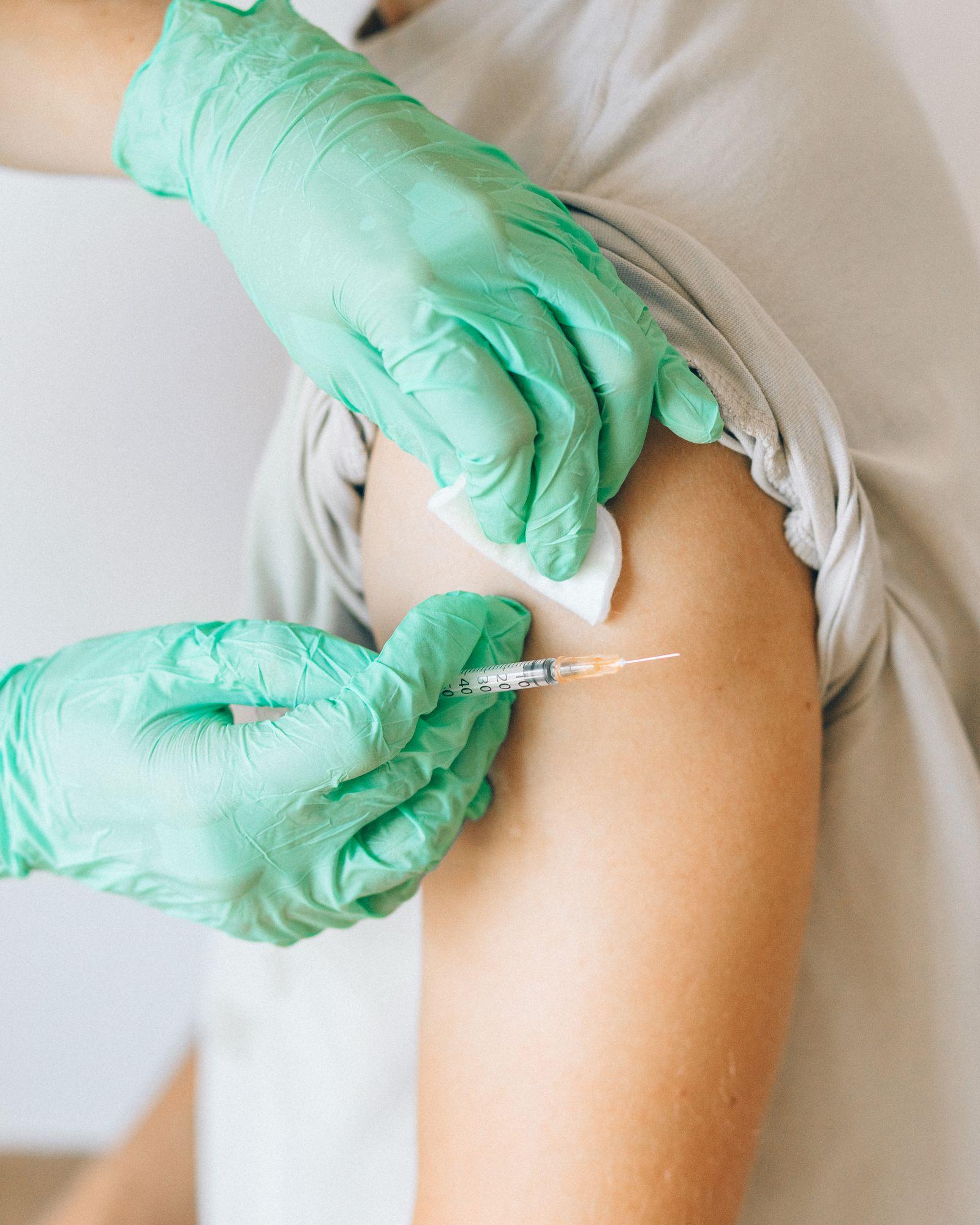 Pharmacist giving a flu vaccination to an employee's upper arm