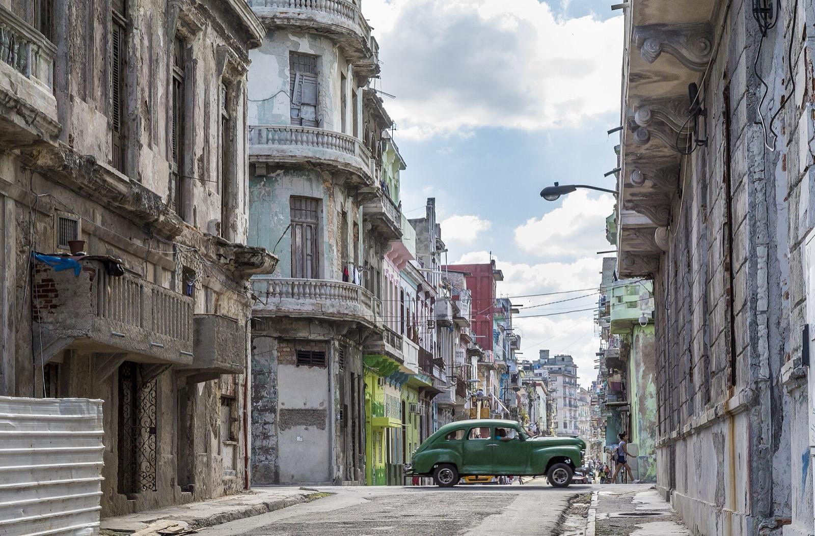 Classic American cars parked along a colourful colonial street in Old Havana, Cuba