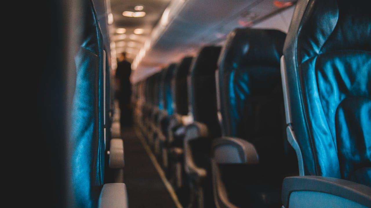 Traveller doing seated calf exercises on a long-haul flight to prevent DVT