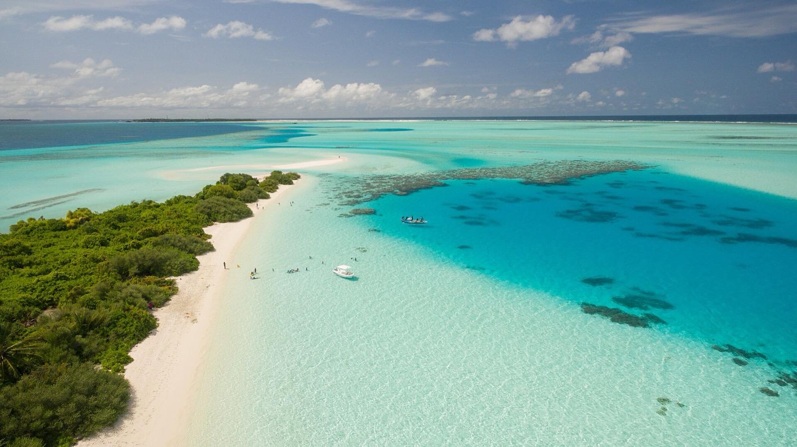 Overwater villas above a turquoise Maldives lagoon at sunset