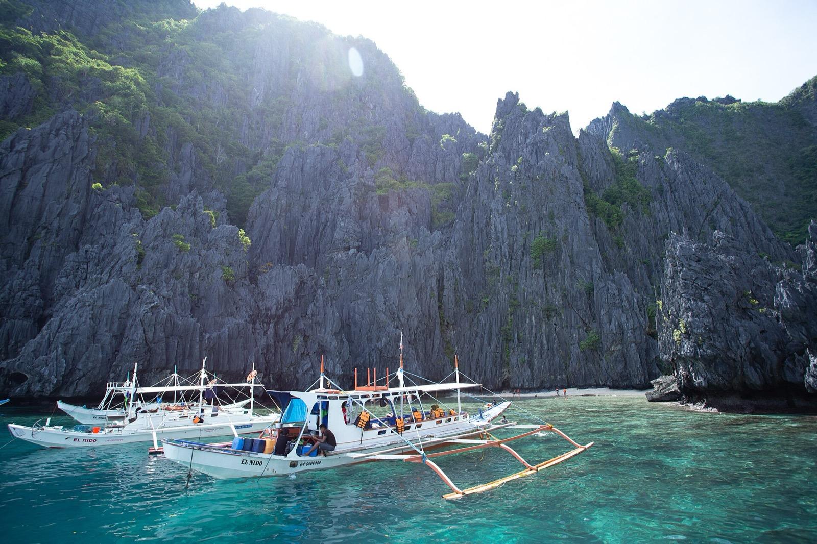 Tropical island coastline in the Philippines with turquoise water and palm trees